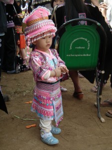 A little Hmong girl dressed in a fancy outfit.  Her mother probably worked the whole year to sew such a fancy outfit.